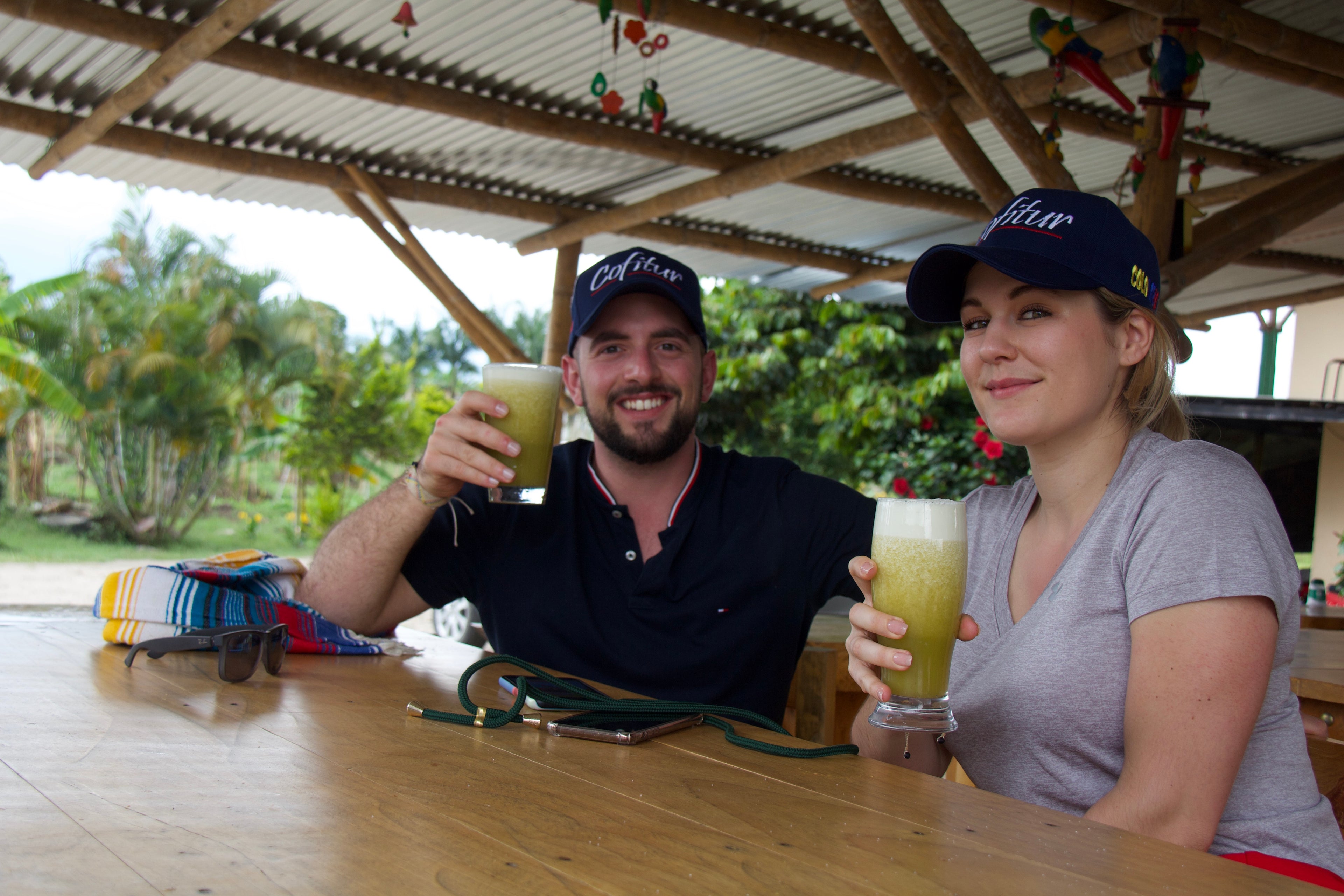 Vera Richartz und Frederic Bertolone von Cofitur bei einer Saftpause in Kolumbien – entspannter Moment der Partnerschaft und Nähe im Arbeitsalltag auf der Kaffeefinca
